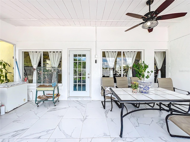 sunroom featuring ceiling fan and wood ceiling