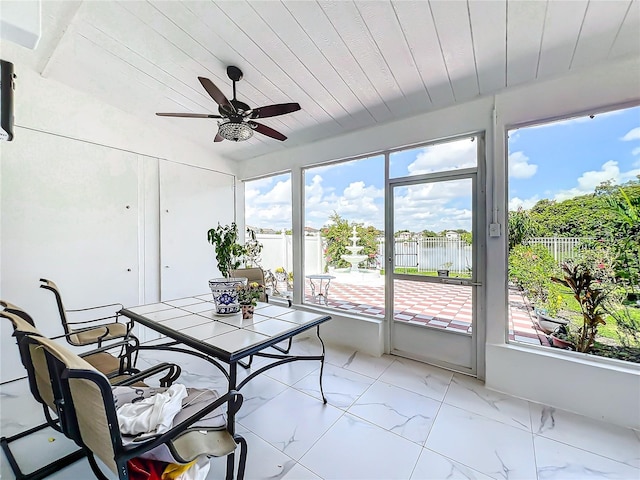 sunroom / solarium featuring ceiling fan, wood ceiling, and a water view