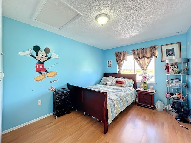 bedroom with a textured ceiling and hardwood / wood-style floors