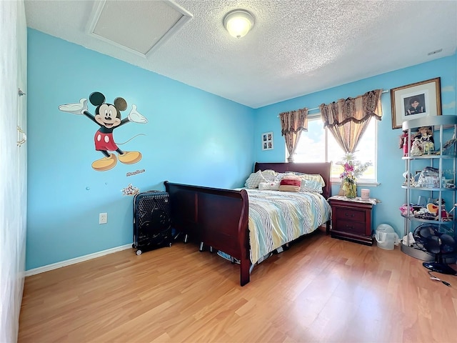 bedroom with a textured ceiling and light wood-type flooring