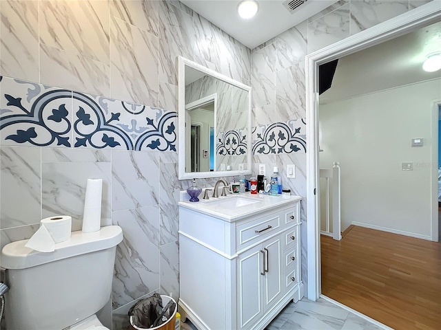 bathroom featuring tile walls, vanity, and toilet