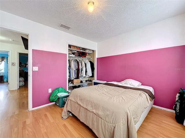 bedroom featuring a textured ceiling, a closet, and wood-type flooring