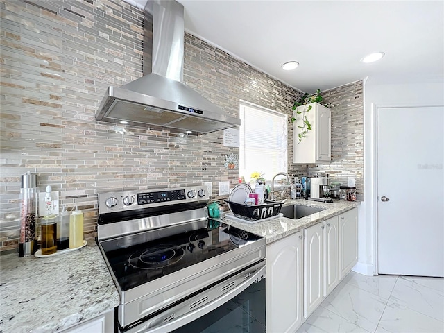 kitchen with white cabinets, stainless steel electric range, wall chimney range hood, and sink