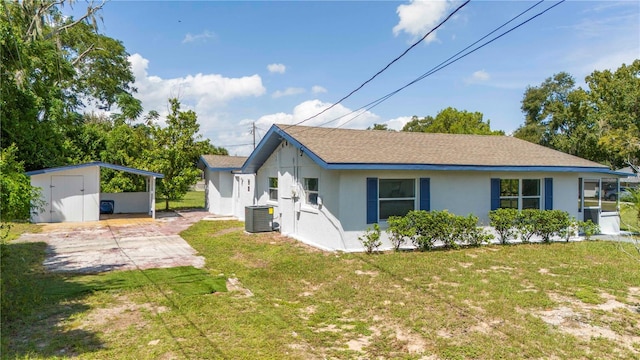 view of front of house featuring a front yard, cooling unit, and a carport