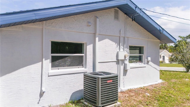 view of property exterior featuring cooling unit and a lawn