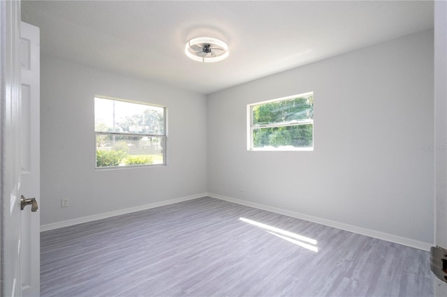 unfurnished room featuring hardwood / wood-style floors, ceiling fan, and plenty of natural light