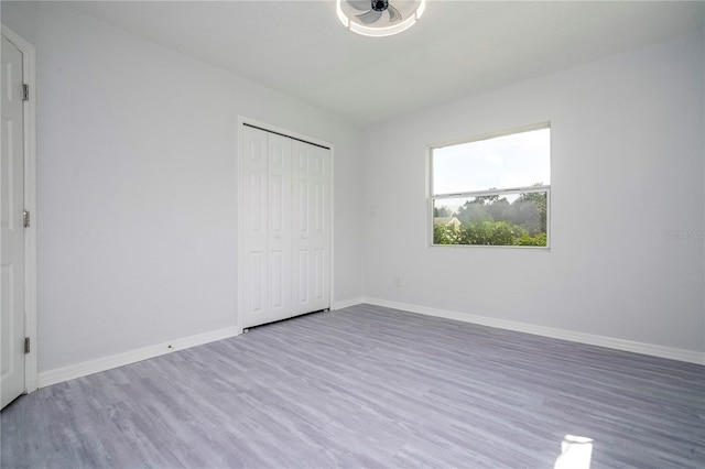 unfurnished bedroom with wood-type flooring and a closet