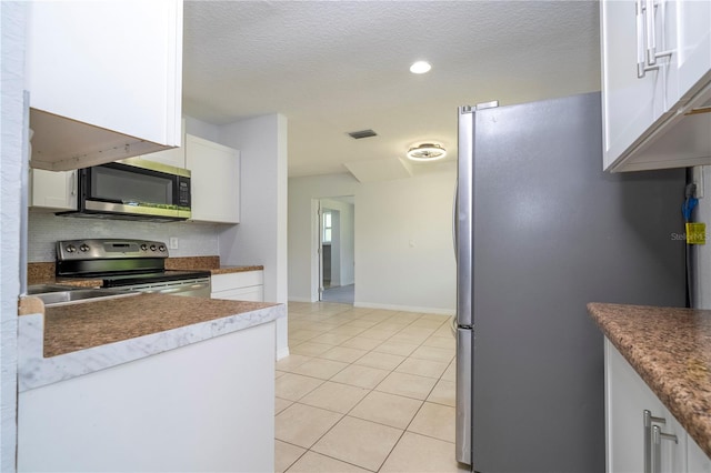 kitchen featuring a textured ceiling, white cabinets, stainless steel appliances, and light tile patterned floors