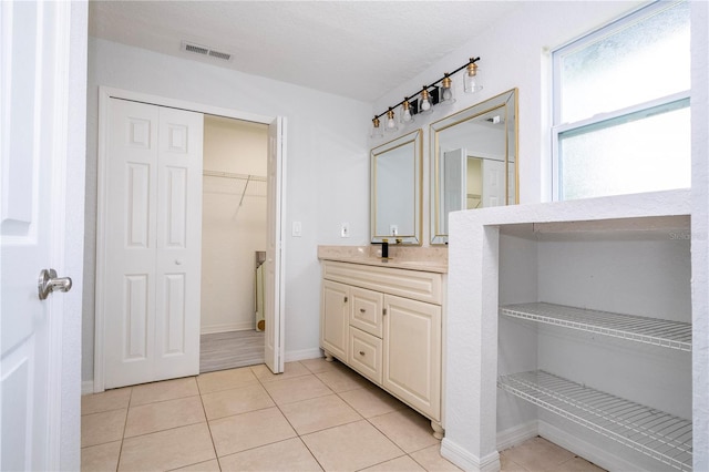 bathroom with vanity, a textured ceiling, and tile patterned floors