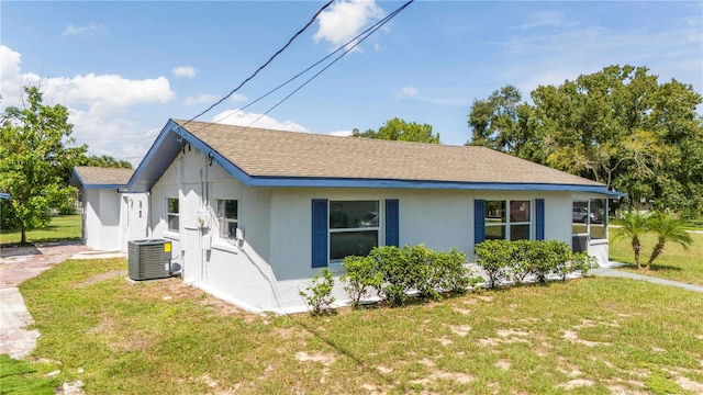 view of side of property with a yard and cooling unit