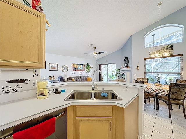 kitchen with vaulted ceiling, stainless steel dishwasher, light brown cabinetry, and sink