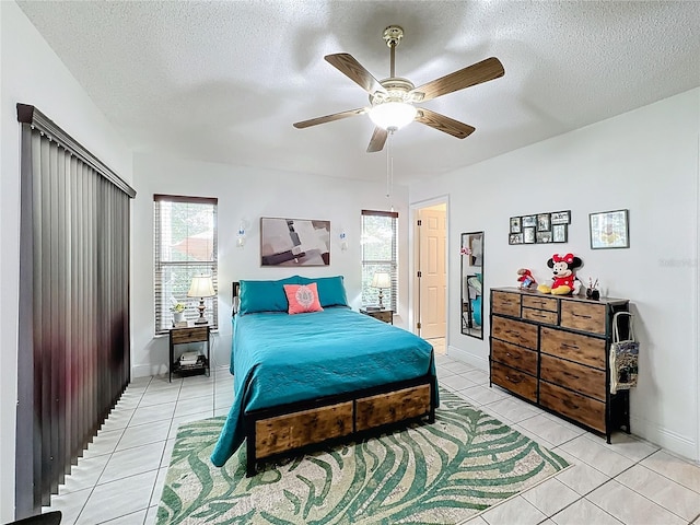 bedroom featuring a textured ceiling, light tile patterned flooring, and ceiling fan