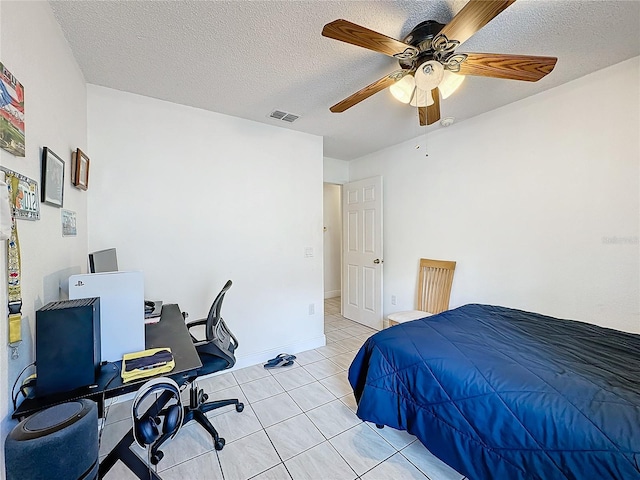 bedroom with ceiling fan, a textured ceiling, and light tile patterned flooring