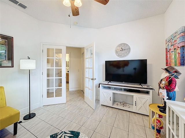 tiled living room with ceiling fan and a textured ceiling