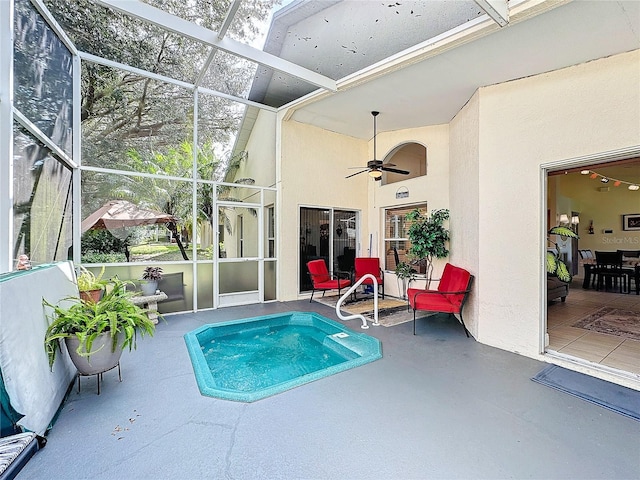 view of pool with glass enclosure, ceiling fan, and a patio