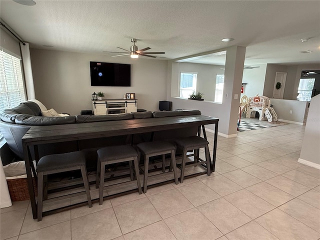 tiled living room featuring a textured ceiling and ceiling fan