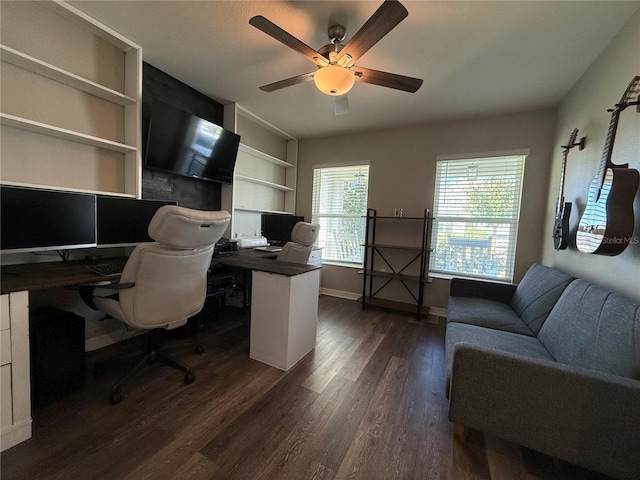 office with built in shelves, ceiling fan, and dark wood-type flooring