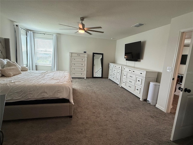 carpeted bedroom with ceiling fan and a textured ceiling