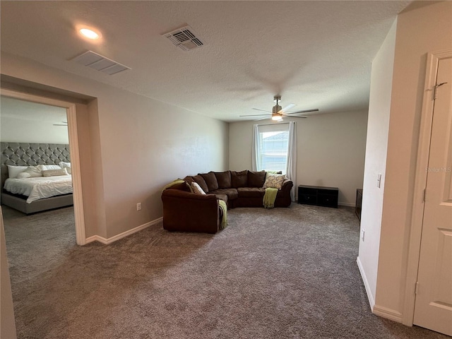 carpeted living room with a textured ceiling and ceiling fan