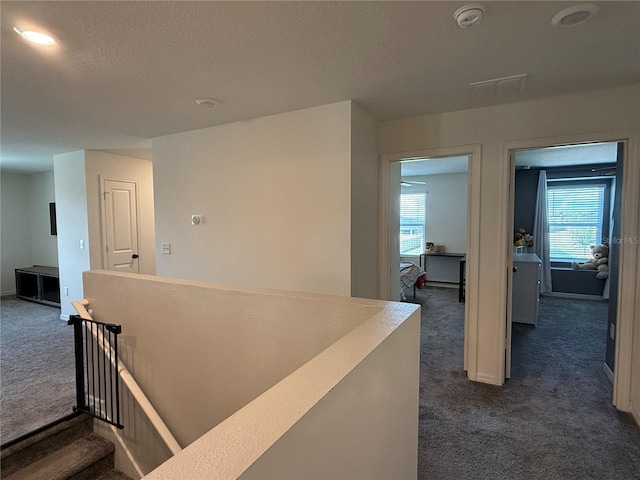 2346 Upland Ln, Apopka, FL 32712 - hallway with dark colored carpet, plenty of natural light, an upstairs landing, a textured ceiling, and baseboards