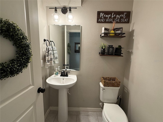 bathroom with sink, toilet, and tile patterned flooring