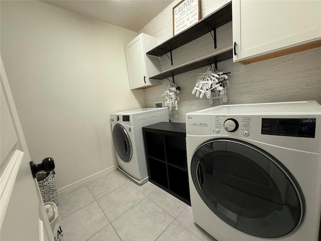 2346 Upland Ln, Apopka, FL 32712 - laundry room featuring washer and clothes dryer, cabinet space, light tile patterned floors, and baseboards