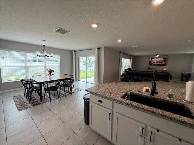 2346 Upland Ln, Apopka, FL 32712 - kitchen with a sink, white cabinets, light tile patterned flooring, decorative light fixtures, and a chandelier