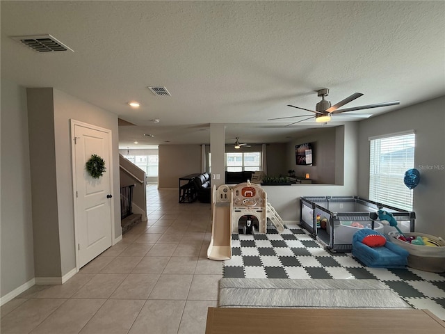 2346 Upland Ln, Apopka, FL 32712 - recreation room featuring a ceiling fan, healthy amount of natural light, baseboards, a textured ceiling, and light tile patterned floors