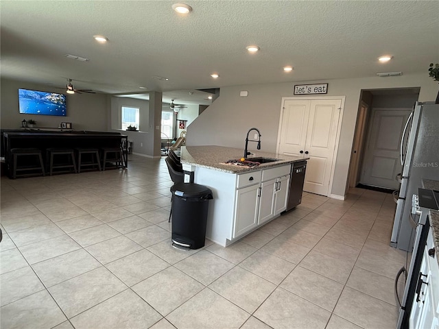 2346 Upland Ln, Apopka, FL 32712 - kitchen with a sink, ceiling fan, light stone counters, light tile patterned floors, and a textured ceiling