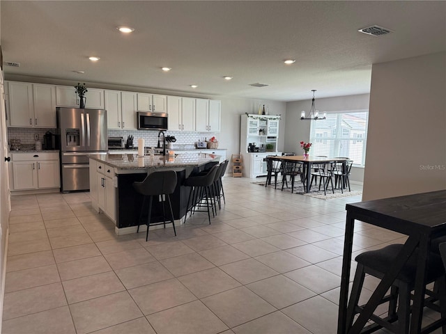 2346 Upland Ln, Apopka, FL 32712 - kitchen with stainless steel appliances, tasteful backsplash, a chandelier, an island with sink, and recessed lighting