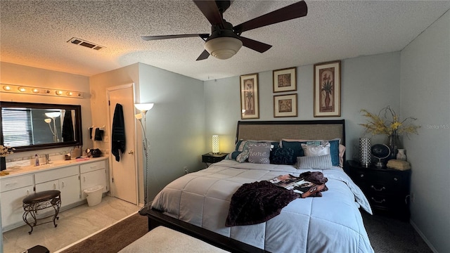 carpeted bedroom with ceiling fan and a textured ceiling