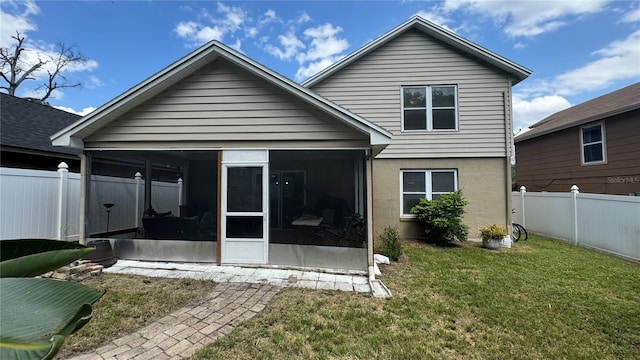 back of house with a sunroom and a yard