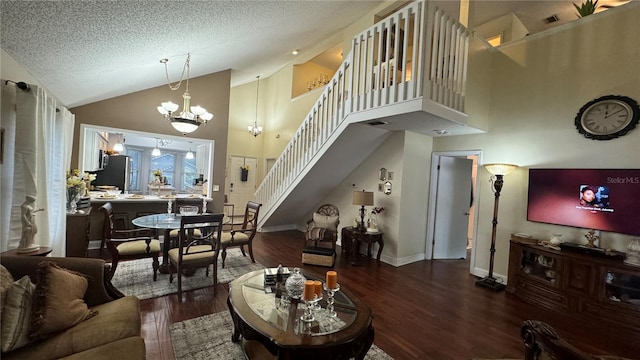 living room featuring a textured ceiling, hardwood / wood-style flooring, an inviting chandelier, and high vaulted ceiling