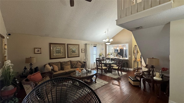 living room featuring a textured ceiling, wood-type flooring, lofted ceiling, and ceiling fan with notable chandelier