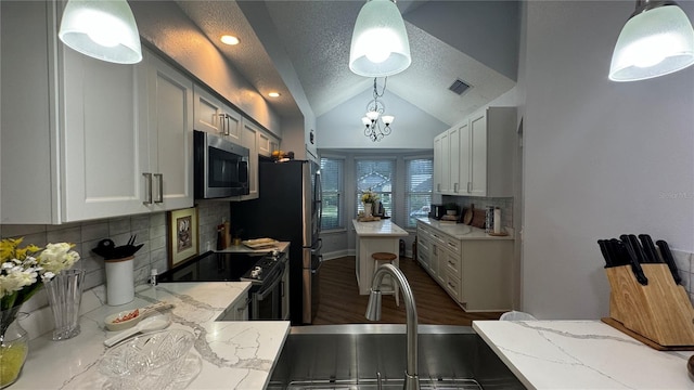 kitchen with decorative light fixtures, backsplash, vaulted ceiling, and electric range