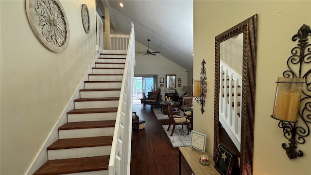 stairway with high vaulted ceiling, wood-type flooring, ceiling fan, and a textured ceiling