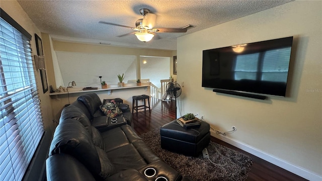 living room featuring ceiling fan, hardwood / wood-style flooring, and a textured ceiling