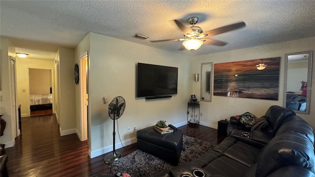 living room with a textured ceiling, dark hardwood / wood-style flooring, and ceiling fan