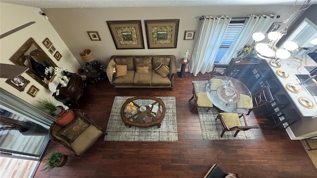 living room featuring a textured ceiling, an inviting chandelier, and dark hardwood / wood-style flooring