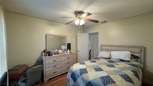 bedroom featuring a textured ceiling, dark hardwood / wood-style floors, and ceiling fan