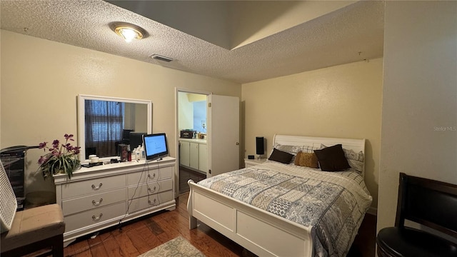 bedroom featuring a textured ceiling and dark wood-type flooring