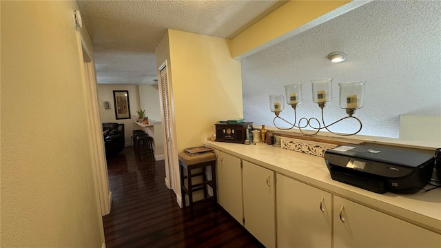 kitchen featuring a textured ceiling and dark wood-type flooring