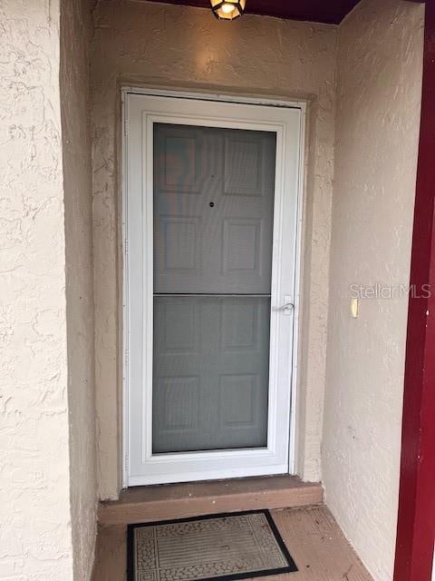 doorway to property featuring stucco siding