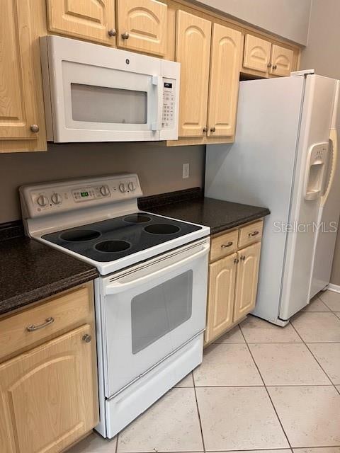 kitchen with white appliances, light tile patterned floors, and light brown cabinets