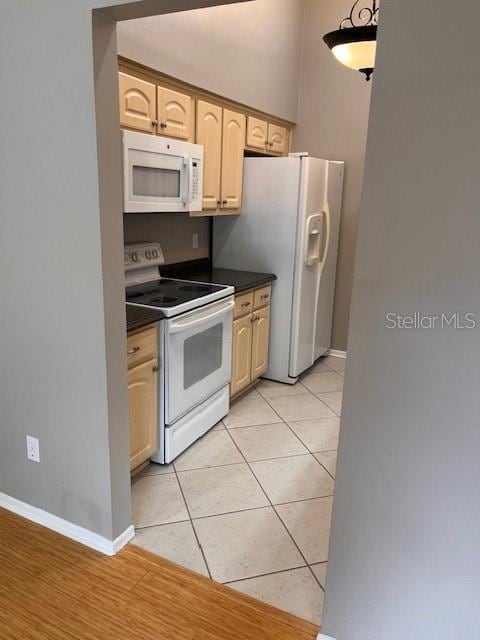 kitchen with light brown cabinets, light hardwood / wood-style flooring, and white appliances