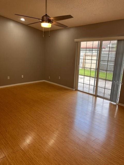 spare room with a textured ceiling, light hardwood / wood-style floors, and ceiling fan