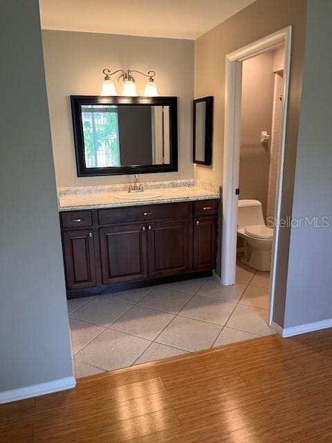 bathroom featuring vanity, toilet, and hardwood / wood-style flooring