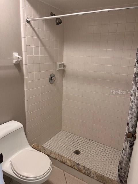 bathroom featuring toilet and a shower with shower curtain