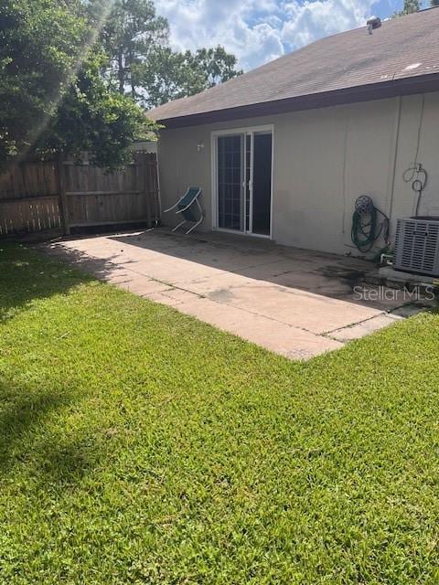 rear view of house featuring a patio, central AC, and a lawn