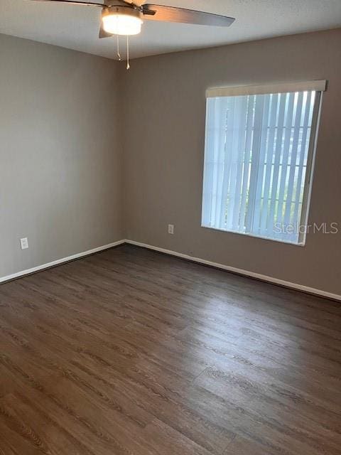 spare room featuring ceiling fan and dark hardwood / wood-style flooring